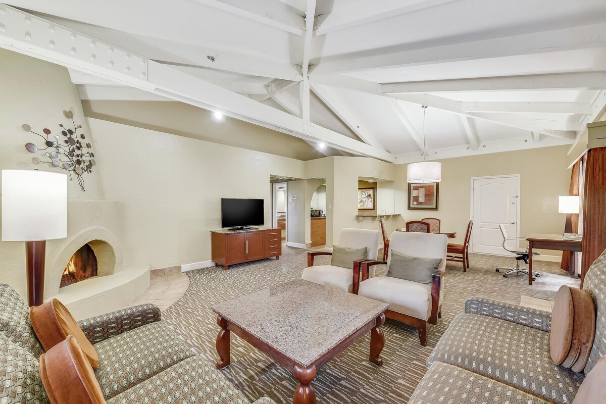 A living room with a fireplace, sofa, coffee table, and television.
