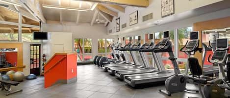 A gym with treadmills, exercise balls, and a staircase.