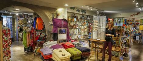 Una tienda boutique con diversos textiles y accesorios a la vista.