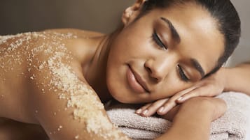 A person lying down with a towel and salt on their shoulder.