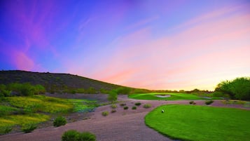 Un campo de golf con cielo despejado y atardecer.