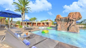 Relax by the serene pool surrounded by a natural rock formation and lounge chairs.