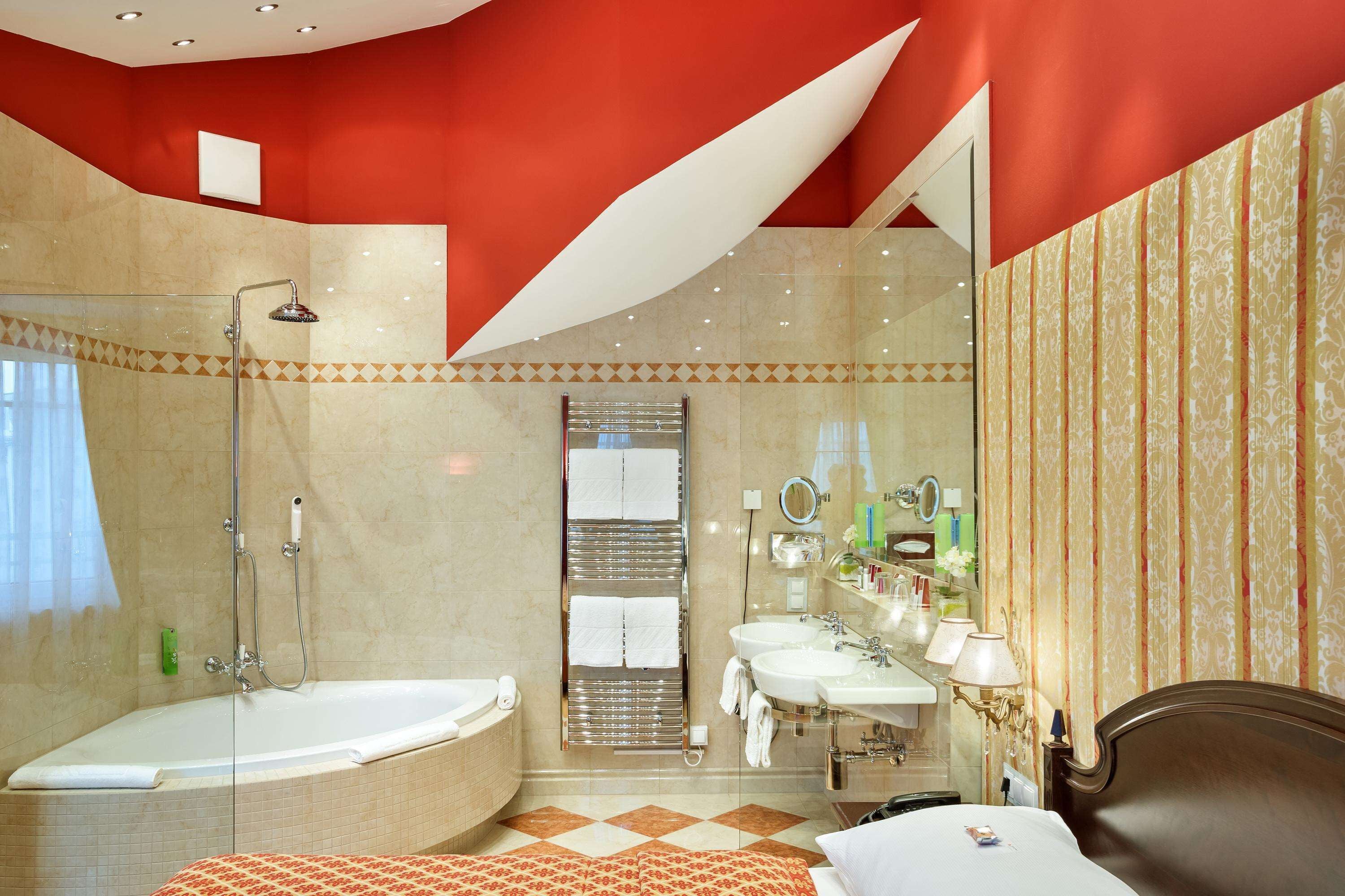A modern bathroom with a bathtub, shower, and two sinks.