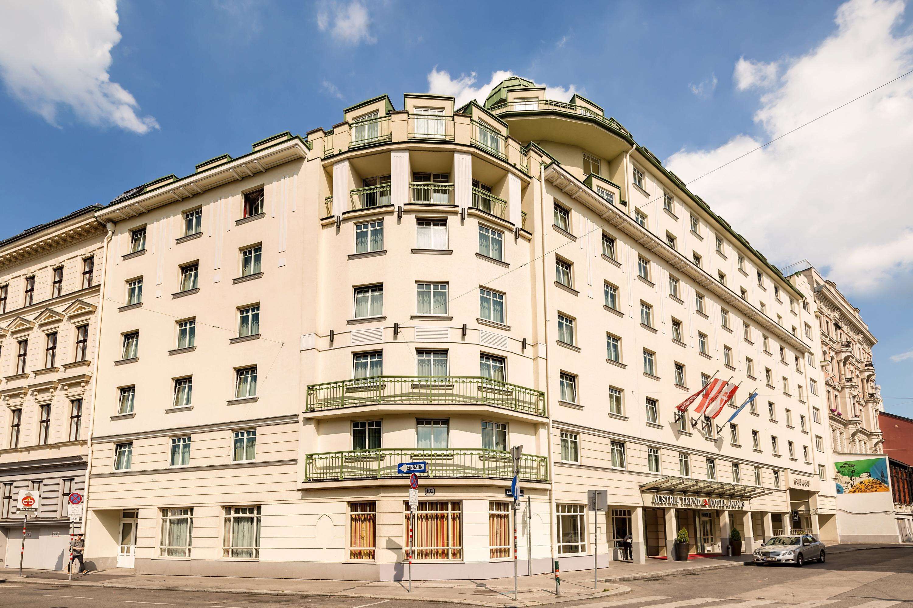 A multi-story hotel with a curved facade, balconies, and a prominent entrance.