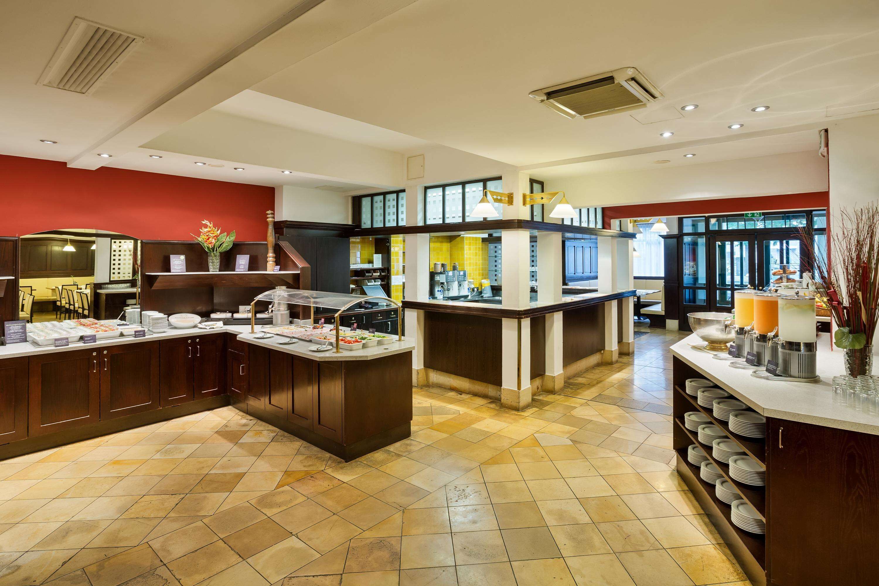 Un espace pour le petit-déjeuner à l’hôtel, avec un buffet, un coin café et un espace détente.