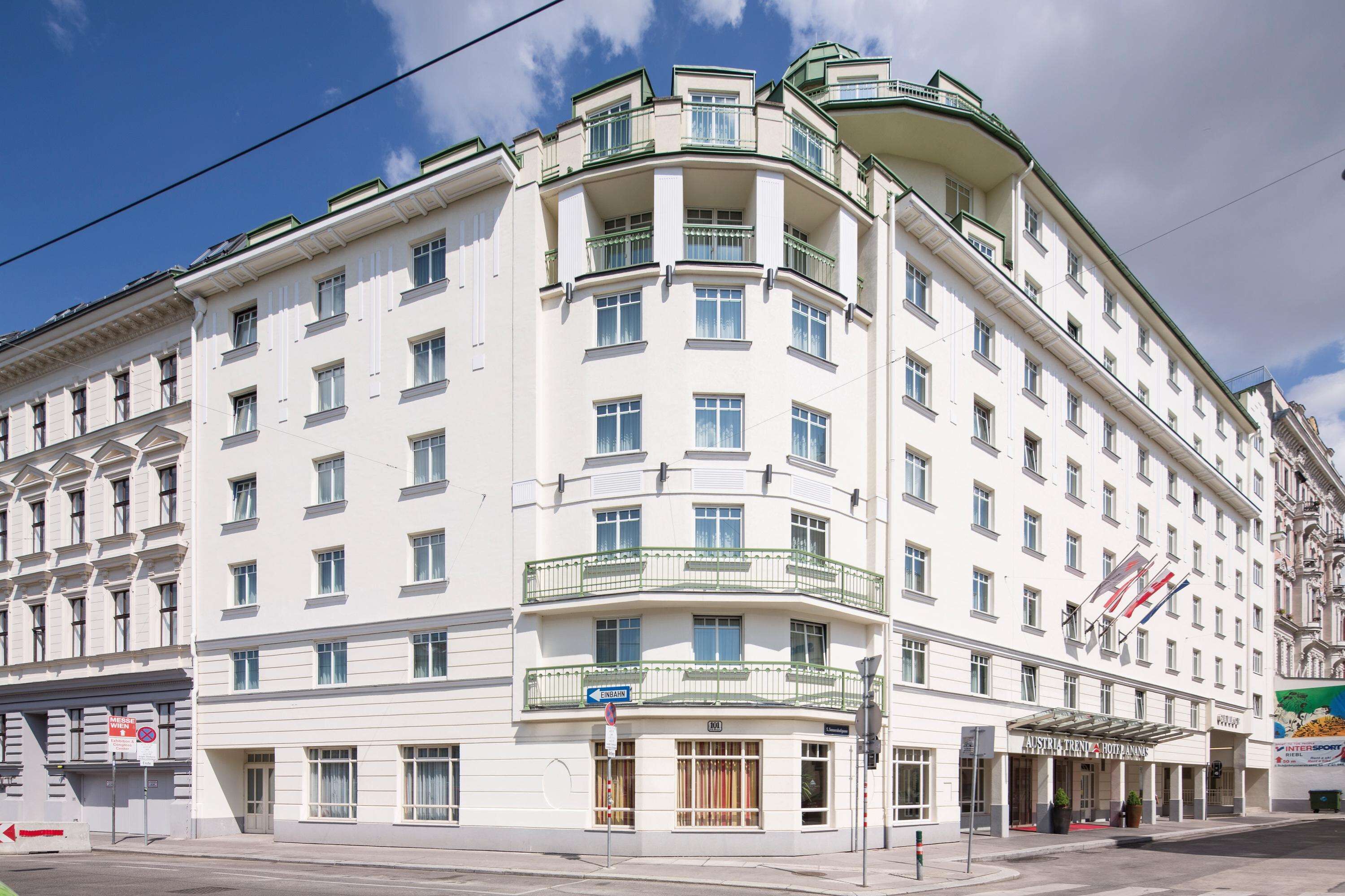 A multi-story hotel with a classic architectural design, featuring balconies and a prominent entrance.