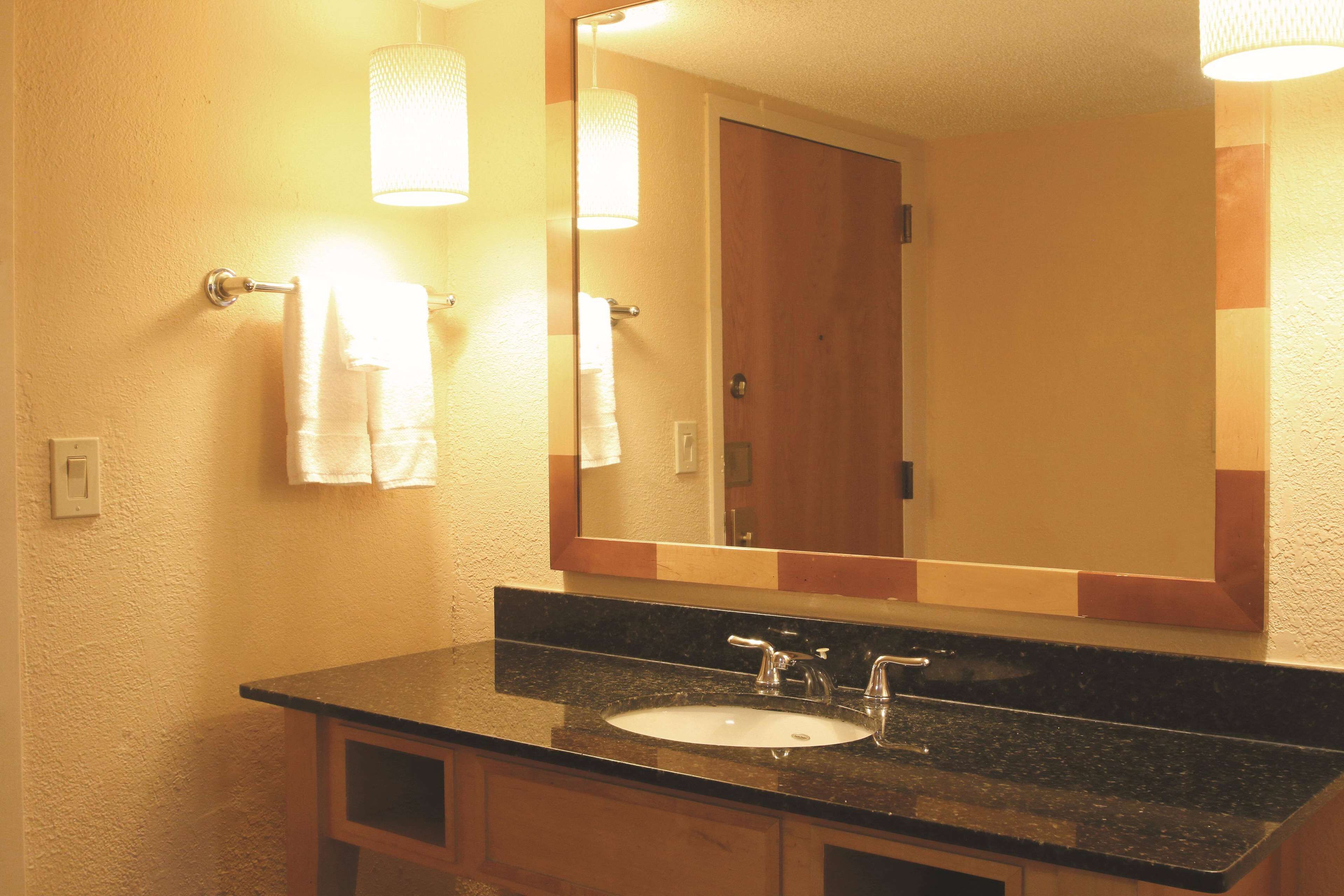 Une salle de bain avec un lavabo, un miroir et un porte-serviettes.
