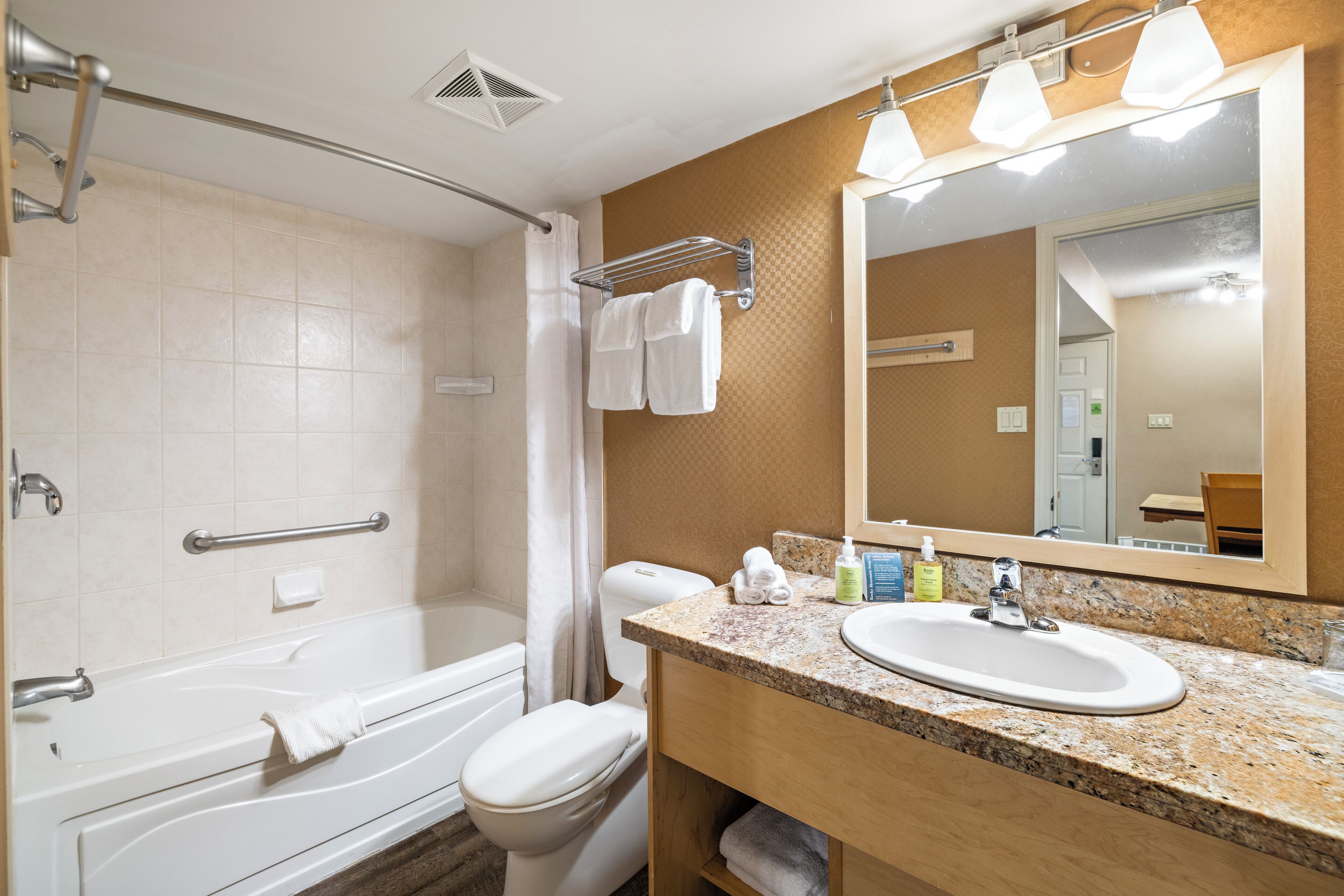 Un baño con bañera, inodoro, lavabo y espejo.