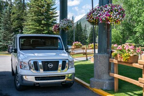 A white truck parked in a scenic area with wooden fences and flower baskets. - Banff Rocky Mountain Resort (Banff)