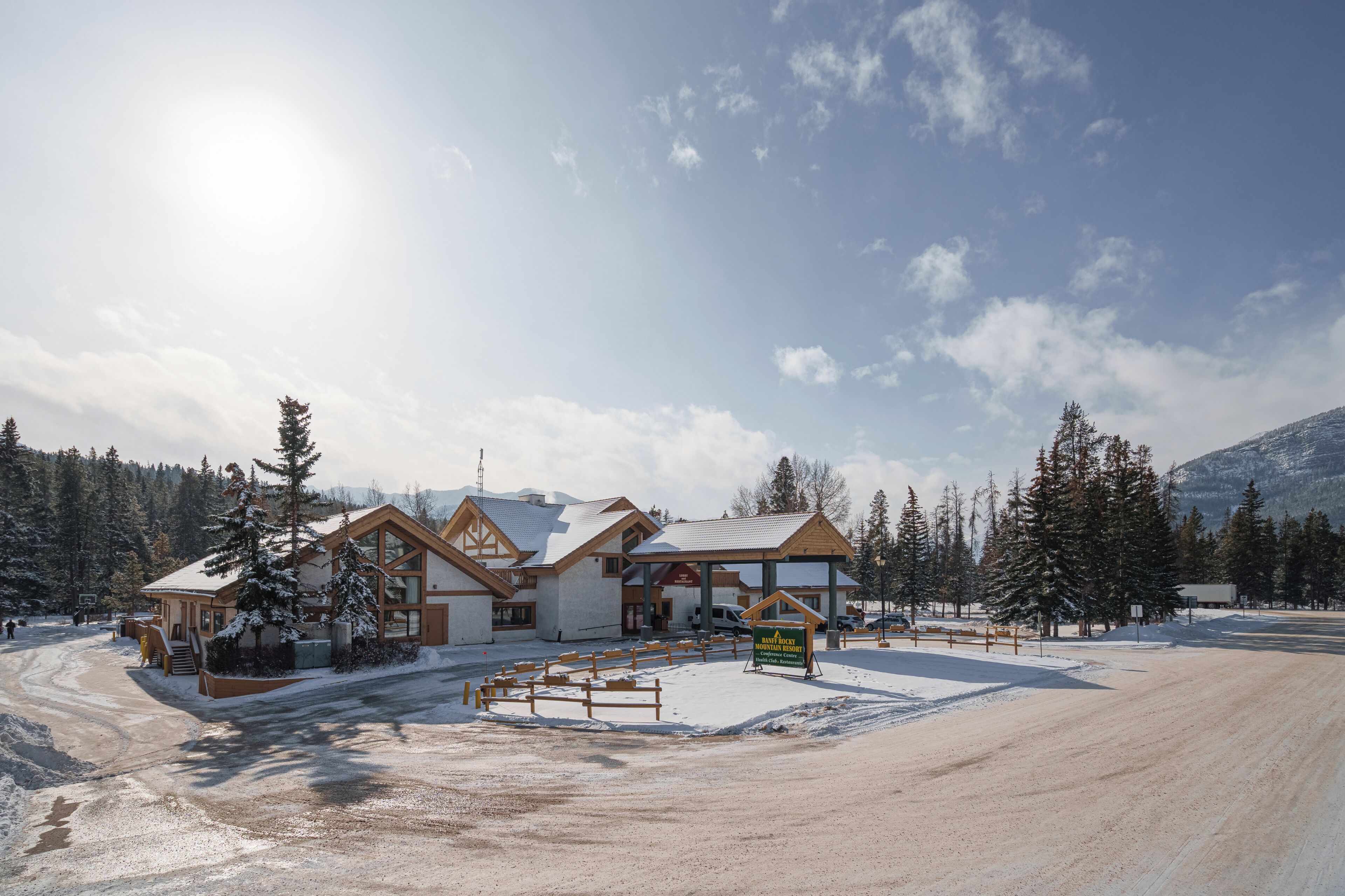 A mountain resort with a conference center, wooden cabins, and a snow-covered landscape.