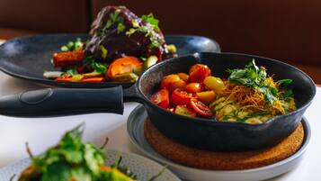 Uma mesa de jantar com diversos pratos, incluindo uma tigela de legumes mistos e um prato com carne.