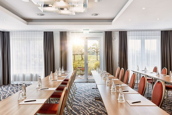 A conference room with long tables, chairs, and water bottles. - H+ Hotel Frankfurt Airport West (Hofheim am Taunus)