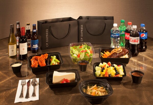 Una mesa con diversos alimentos, bebidas y una bolsa de CP EXPRESS.