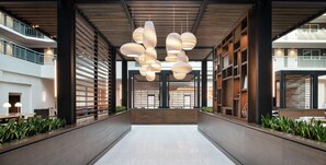 A modern interior with a central walkway, wooden ceiling beams, and hanging pendant lights. - Embassy Suites by Hilton Walnut Creek (Walnut Creek)