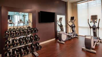 A gym with weightlifting equipment, treadmills, and stationary bikes.