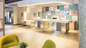 A modern reception area with a curved ceiling, a reception desk, and a wall with large letters spelling out a word.