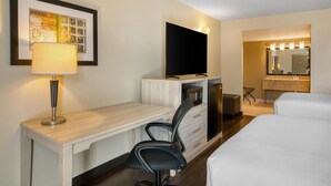A hotel room with a desk, chair, bed, TV, and a bathroom with a mirror and lights. - Best Western Battlefield Inn-Manassas (Manassas)