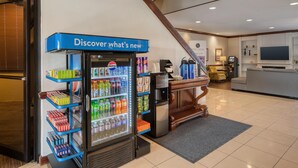 A vending machine stocked with various beverages and snacks, a coffee machine, and a seating area with a television. - Best Western Battlefield Inn-Manassas (Manassas)