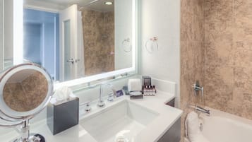 Une salle de bain moderne avec un grand miroir, un lavabo, une baignoire et un espace douche.
