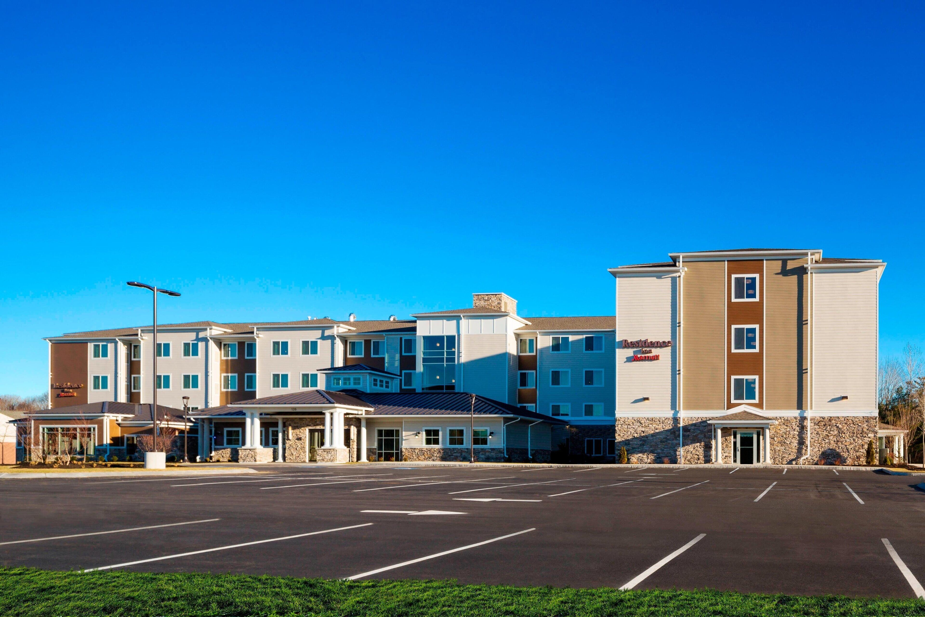 A multi-story hotel with a parking lot in front.