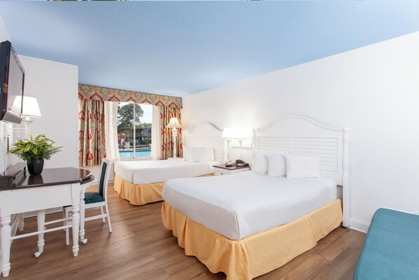 A hotel room with two beds, a desk, and a chair. - Seralago Hotel and Suites Main Gate East (Kissimmee)
