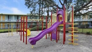 A playground with a purple slide and various play structures. - Seralago Hotel and Suites Main Gate East (Kissimmee)