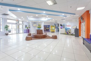 A spacious lobby with a central seating area, a large window, and a vending machine. - Seralago Hotel and Suites Main Gate East (Kissimmee)