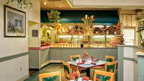 A dining area with tables and chairs, a counter with various items, and a sign indicating no smoking. - Seralago Hotel and Suites Main Gate East (Kissimmee)