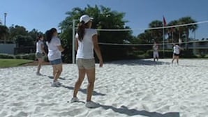 A volleyball game on a sandy court with players in white and blue. - Seralago Hotel and Suites Main Gate East (Kissimmee)