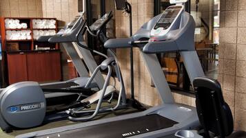 Un gimnasio con cintas de correr y una bicicleta estática.