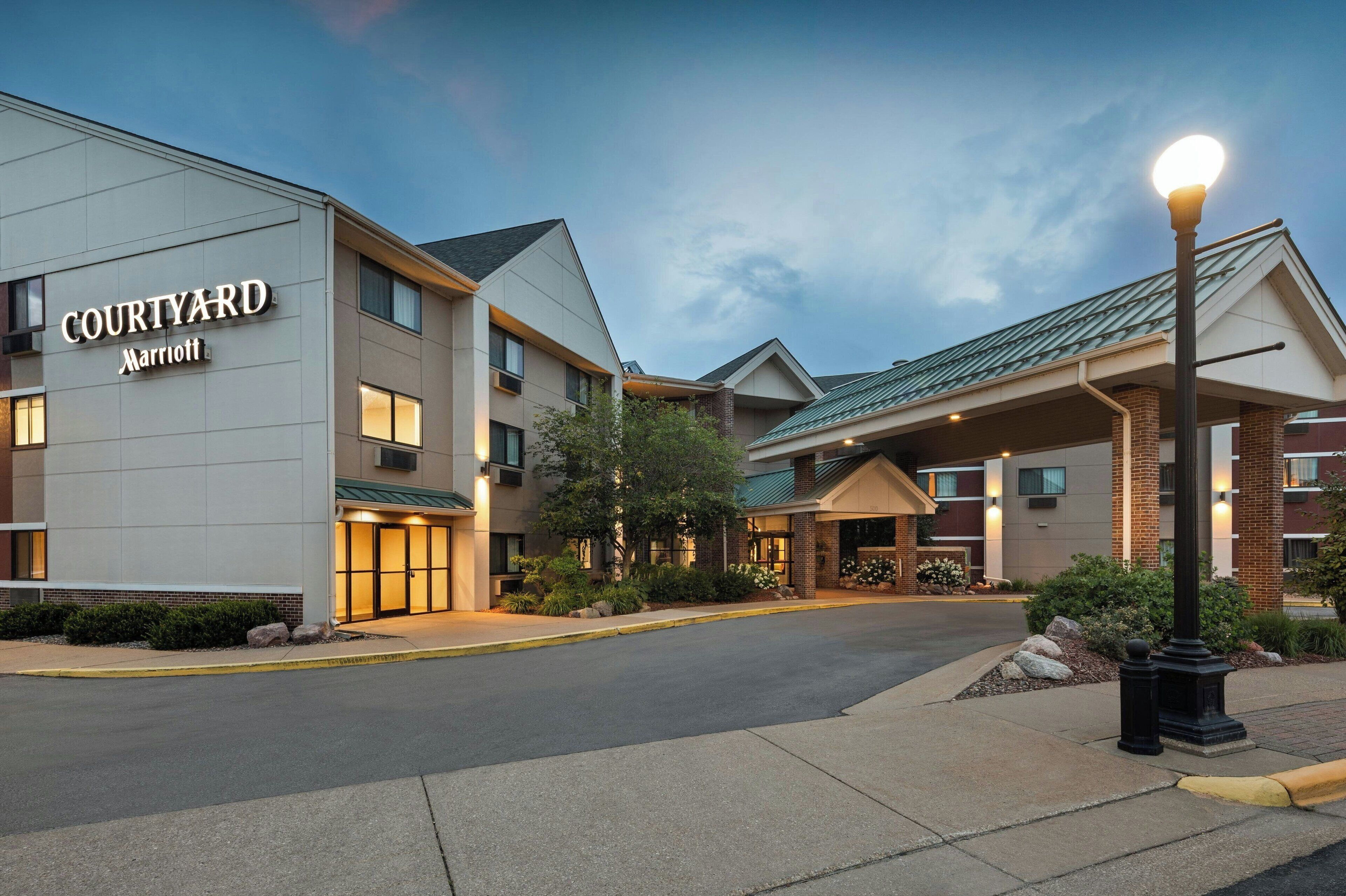 A Courtyard Marriott hotel with a modern design, featuring a covered entrance and multiple floors.