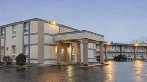 A multi-story hotel with a covered entrance, a parking lot, and a clear sky. - SureStay by Best Western Brockville (Brockville)