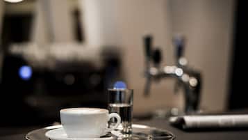 A cup of coffee and a glass of water on a tray.