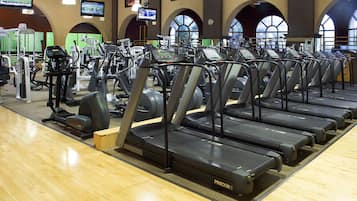 Et fitnesscenter med flere løbebånd, træningscykler og styrkemaskiner.