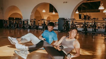 A gym with exercise equipment, wooden floors, and arched ceilings.
