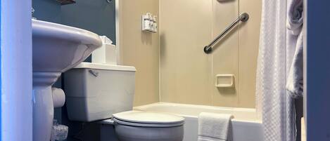 A bathroom with a toilet, sink, and bathtub.