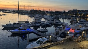 Un puerto deportivo con varias embarcaciones amarradas a muelles de madera, unidos por pasarelas.