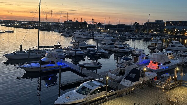 A marina with multiple boats docked at wooden piers, connected by walkways. - The Newport Harbor Hotel & Marina (Newport)