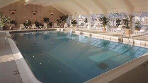 An indoor swimming pool with clear water, surrounded by lounge chairs and potted plants. - The Newport Harbor Hotel & Marina (Newport)
