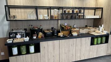 A breakfast bar with a variety of food items, including bread, pastries, and condiments.