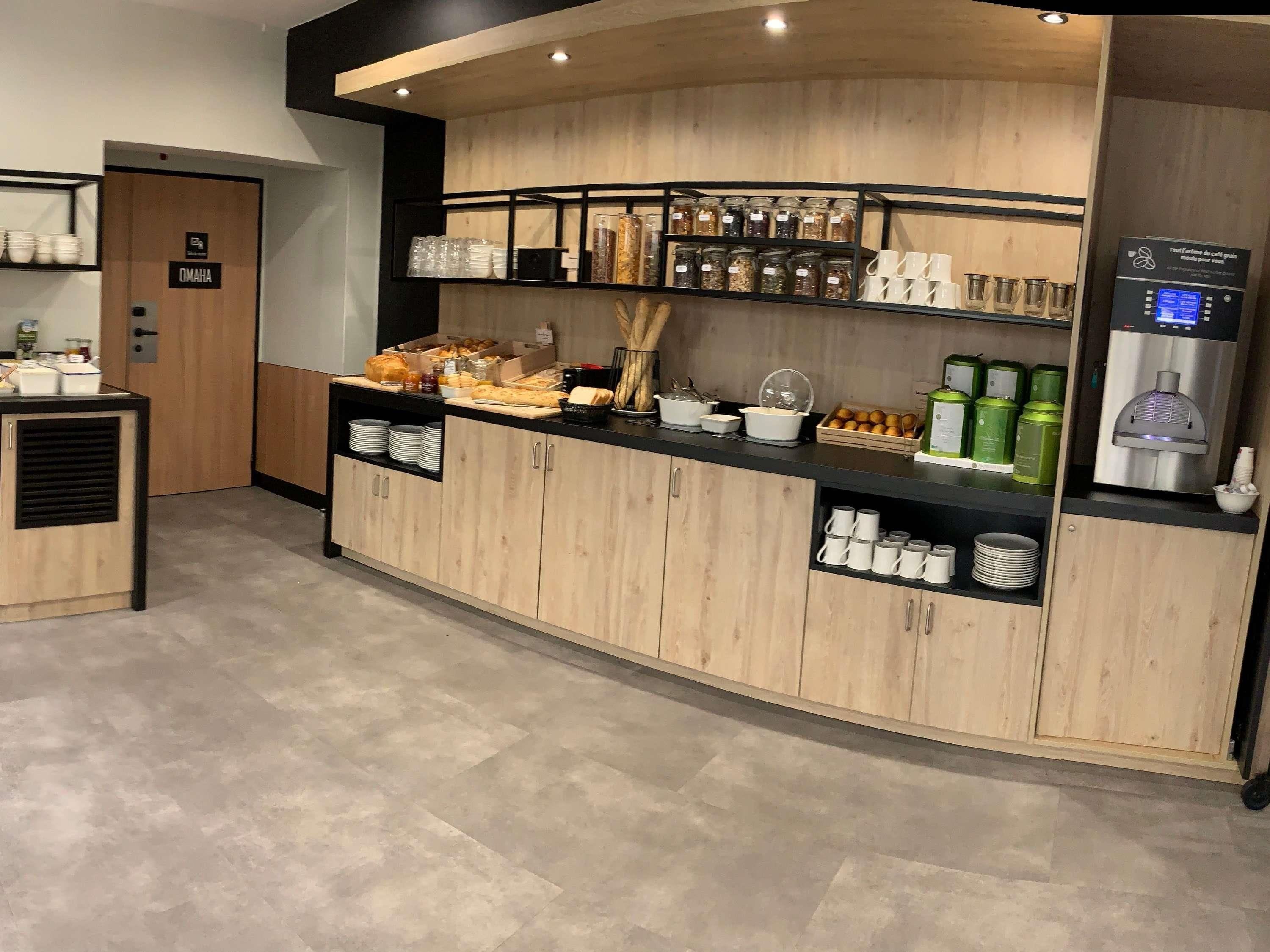 A breakfast bar with a variety of food items, a coffee machine, and a water dispenser.