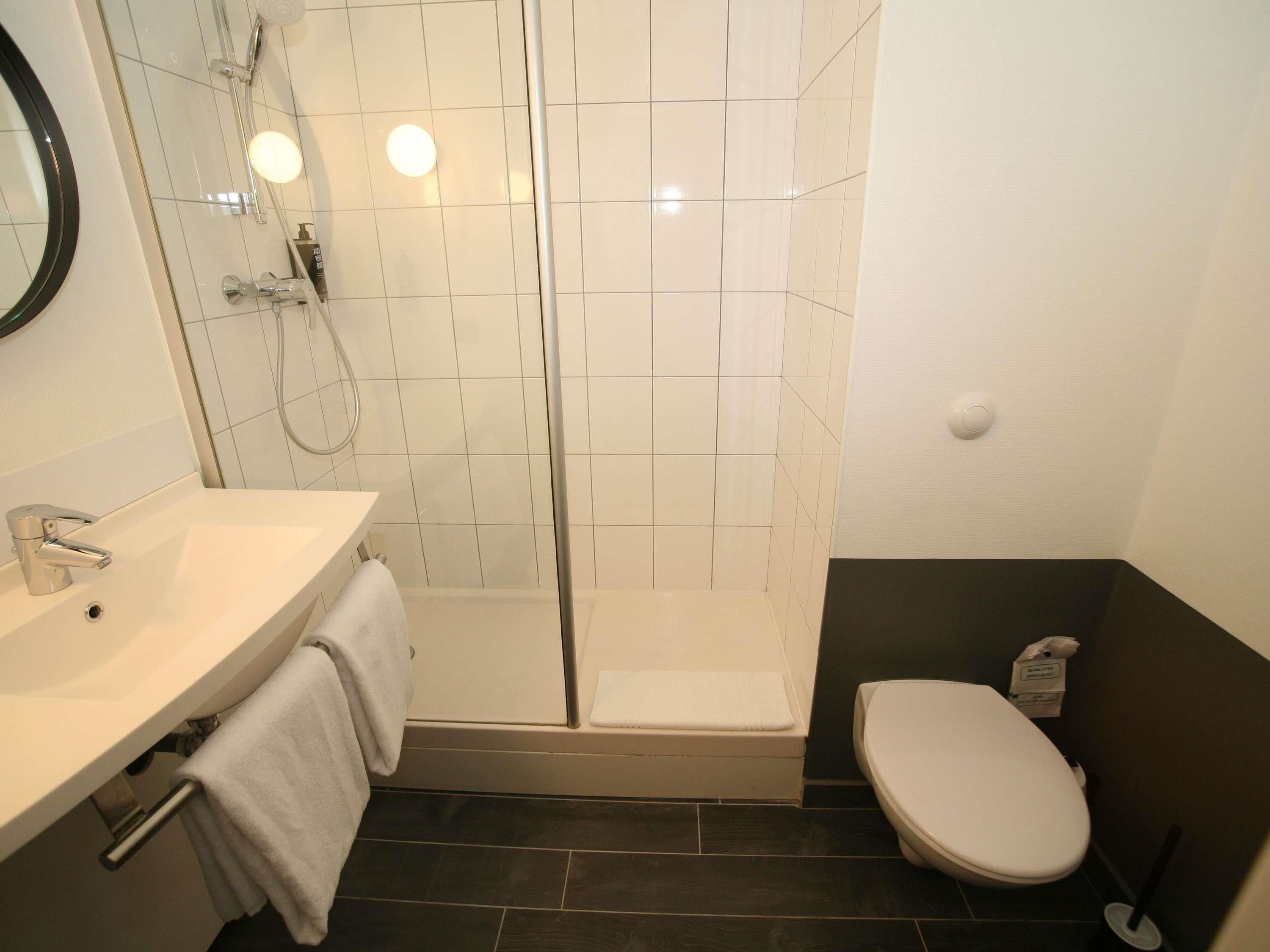 A bathroom with a shower, toilet, and sink.