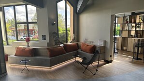 A modern interior with a built-in bench seating area, a dining table with chairs, and a view of the outside through large windows.