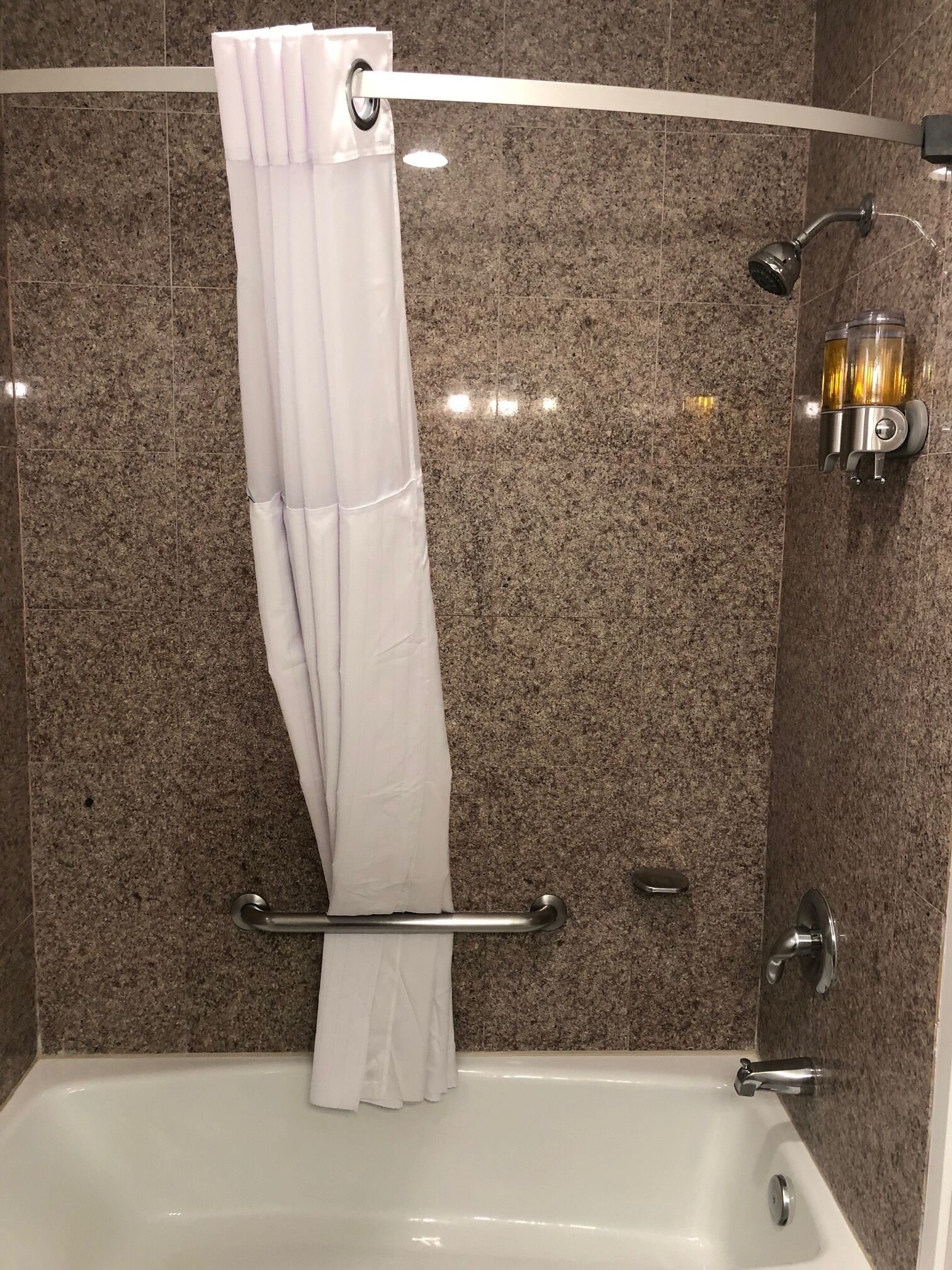 A bathroom with a bathtub, a shower, and a towel rack.