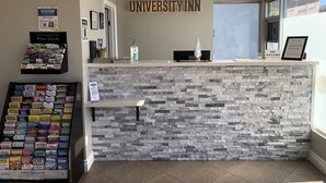 Una reception con facciata in pietra, un orologio e un cartello che recita "UNIVERSITY INN".