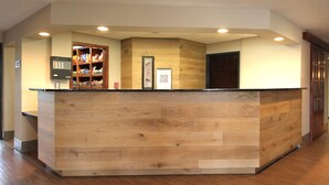A reception desk with a wooden finish, a fire alarm, and a framed artwork on the wall. - Country Inn & Suites by Radisson, Sandusky South, OH (Milan)
