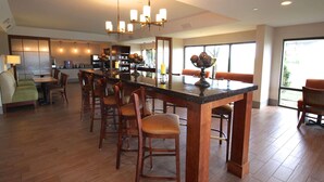 A spacious kitchen with a central island, wooden chairs, and pendant lighting. - Country Inn & Suites by Radisson, Sandusky South, OH (Milan)