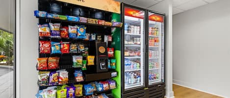 A snack vending machine with a variety of chips and snacks, and a refrigerated display case with beverages.
