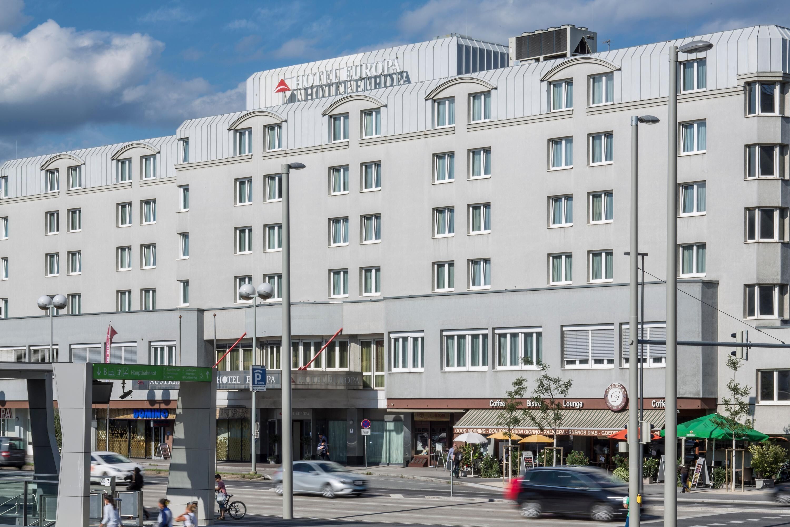 Un hotel de varios pisos con fachada moderna, que presenta un letrero llamativo para Hotel Europa.