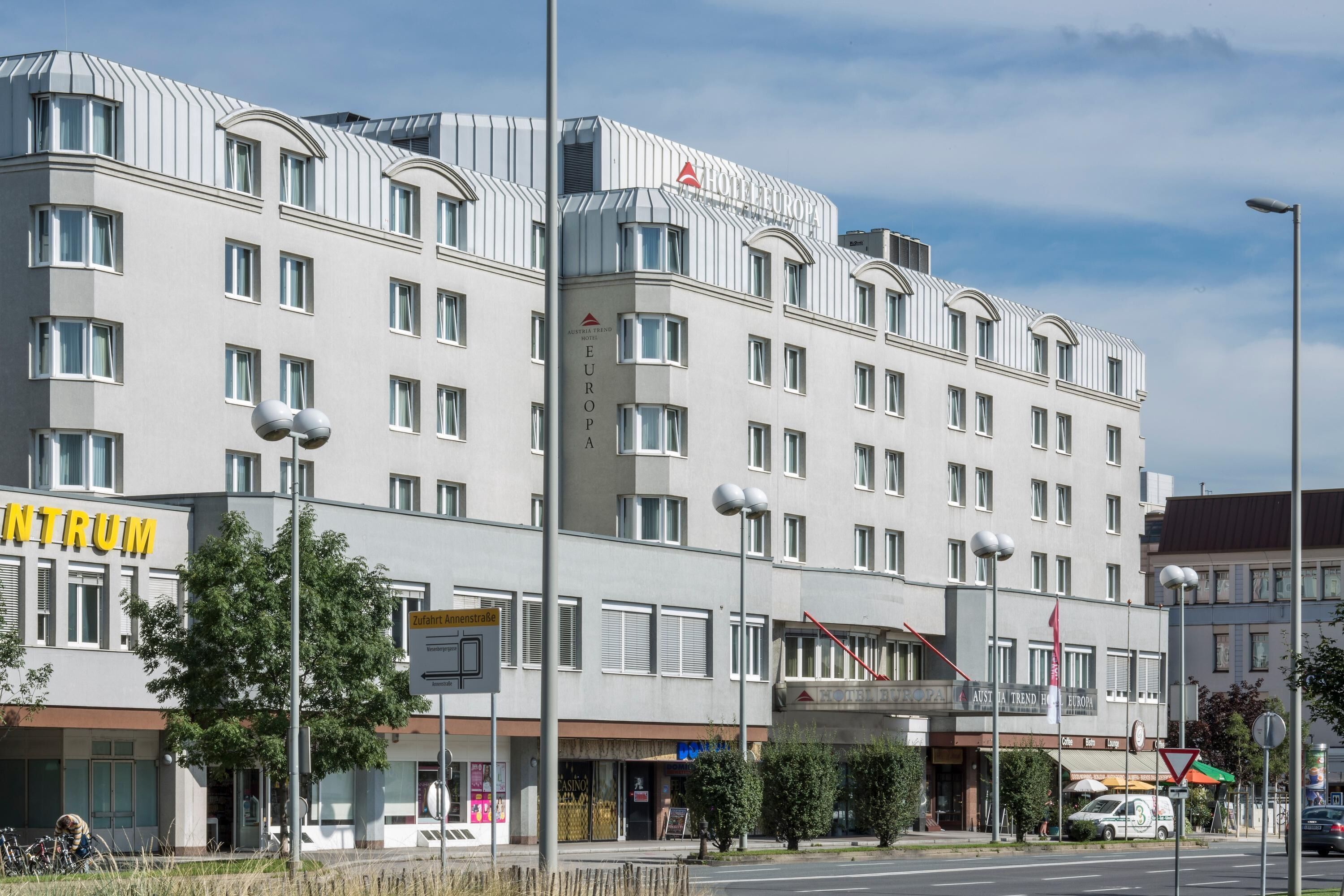 A multi-story hotel with a modern architectural design, featuring a prominent entrance and several windows.